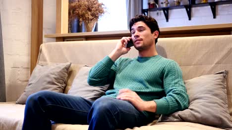 Young-Man-Talking-on-Phone,-Attending-Phone-Call-Sitting-at-Home