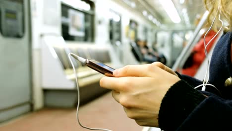 Woman-uses-a-phone-in-the-subway-close-up