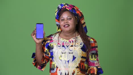 Overweight-beautiful-African-woman-wearing-traditional-clothing-against-green-background