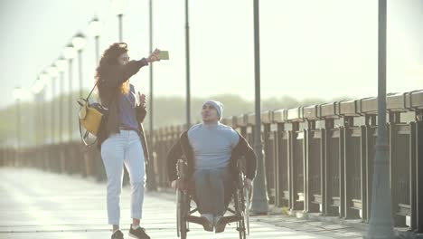 Behinderte-Menschen-im-Rollstuhl-nimmt-He-Foto-der-jungen-Frau-am-Kai