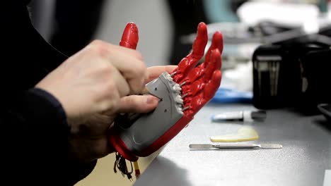 Man-is-working-with-hand-bionic-prosthesis,-sitting-at-table-indoors