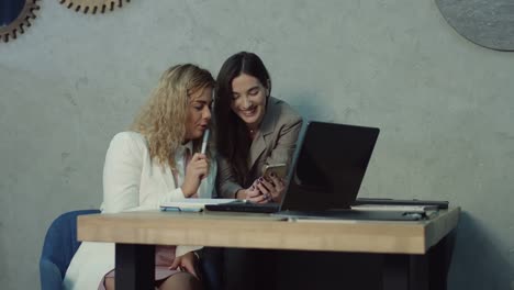 Two-business-colleagues-networking-with-phone