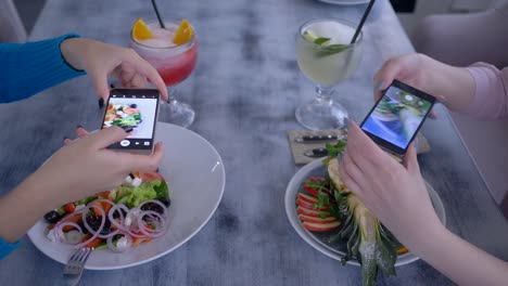 chicas-de-los-vegetarianos-tomar-foto-de-comer-delicioso-en-celular-para-redes-sociales-durante-el-almuerzo-saludable-en-el-restaurante