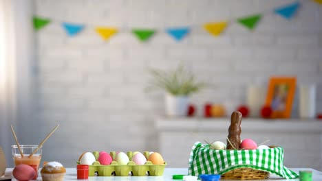 Linda-chica-saltando-como-conejo-por-debajo-de-la-mesa-y-mirando-a-los-huevos-de-Pascua-brillantes