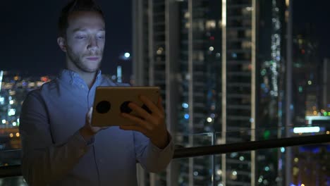 Caucasian-man-using-digital-tablet-for-internet-and-communications-with-cityscape-background