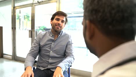 Male-doctor-discussing-with-disabled-patient