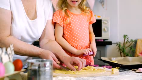 Niña-cortando-galletas-de-Pascua-con-la-abuela