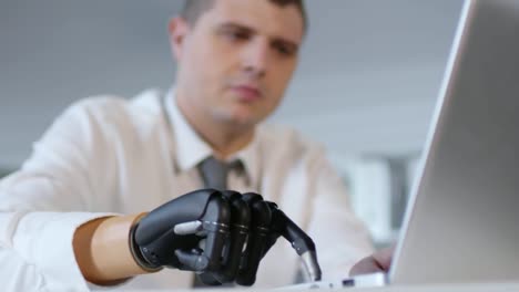 Businessman-with-Artificial-Arm-Typing-on-Laptop