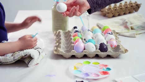 Niña-pequeña-pintando-huevos-de-Pascua-con-pintura-acrílica.