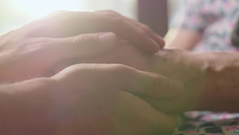 young-person-helps-her-grandmother-to-get-up-taking-her-hands.