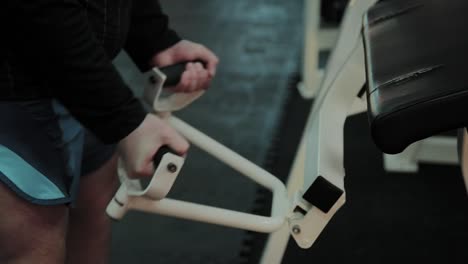 Cheerful-fat-man-performs-a-wrong-exercise-in-the-gym.-For-the-first-time-in-a-fitness-club