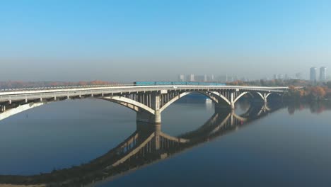 Zwei-U-Bahn-Züge-überqueren-einen-breiten-Fluss-über-die-Brücke