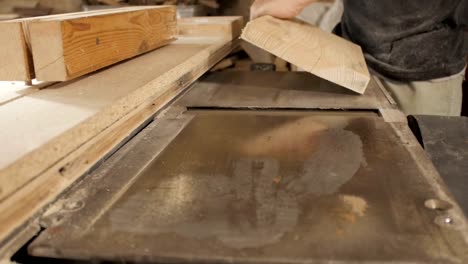 process-of-sanding-a-wooden-board-in-a-workshop,-the-hands-of-man-work-with-wood,-grinding-the-material-on-a-machine,-concept-skill-in-construction,-hobby