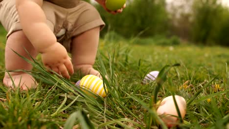 Close-up-of-baby-legs.-A-child-is-looking-for-Easter-eggs-in-the-grass.-Happy-easter-family