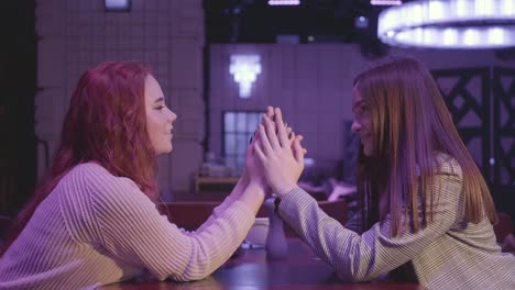 Portrait-of-two-cute-girls-holding-hands-in-blue-light.