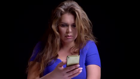 Closeup-shoot-of-middle-aged-caucasian-female-browsing-on-the-phone-and-reacting-to-social-media-posts-then-looking-at-camera-and-smiling