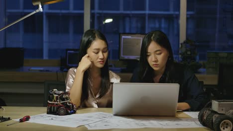 Mujeres-Ingenieros-de-Electrónica-Examinando-Proyecto-en-la-Oficina.-Dos-mujeres-asiáticas-comparan-datos-en-un-ordenador-personal.-Personas-con-concepto-de-tecnología-o-innovación.