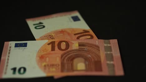 Banknotes-10-euro-slowly-falling-on-the-black-table.-Closeup.-Slow-motion