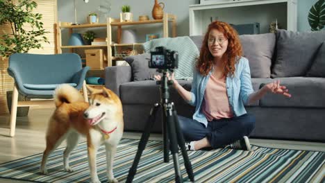 Slow-motion-of-joyful-blogger-dog-owner-recording-video-using-modern-camera