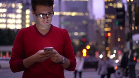 Young-male-blogger-searching-publication-with-information-while-walking-around-city-during-trip-time