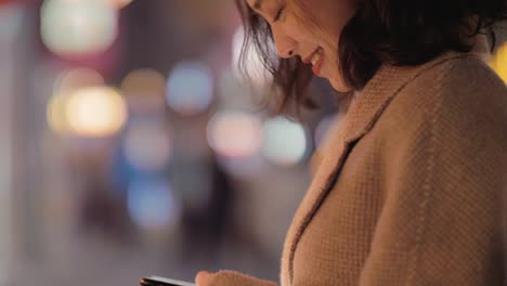 Chinesische-Mädchen-spielen-mit-einem-Handy-mit-Lächeln-in-chengdu