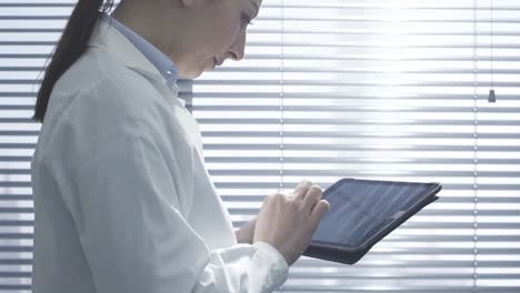 Professional-female-doctor-using-a-digital-tablet