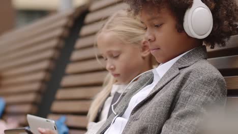 African-Boy-and-Caucasian-Girl-Using-Gadgets-Outdoors