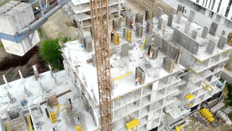 Flight-near-the-unfinished-monolithic-house.-Construction-crane-near-the-construction-site.-Top-view-of-the-construction