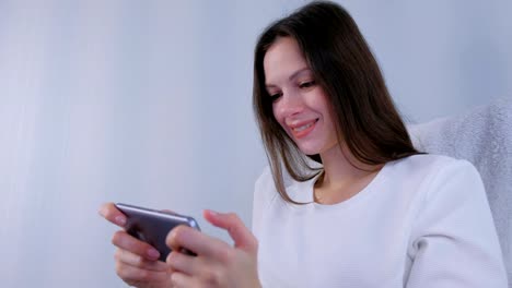 Joven-morena-mujer-está-jugando-juego-en-el-teléfono-móvil.