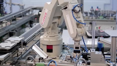 Industry-4.0-smart-factory-concept;-robot-arm-pick-product-from-automated-car-and-place-to-station-to-be-assembly.