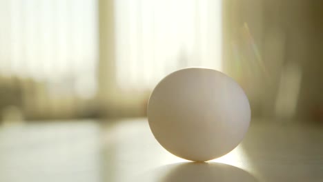 Egg-rotates-on-the-table:-hand-spinning-an-egg,-it-first-turns-quickly