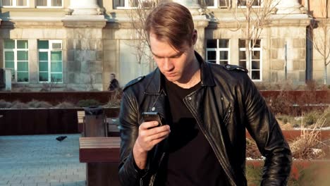 Young-man-in-downtown-using-his-smartphone