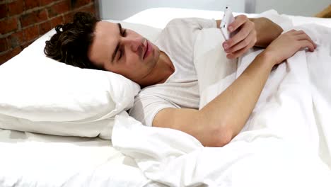 Mann-im-Bett-Surfen-auf-Smartphone-in-der-Nacht