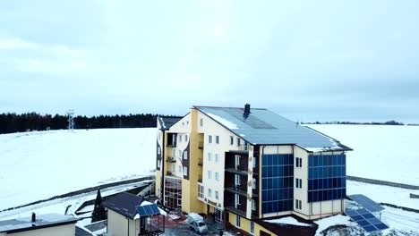 Hotel-complex-in-the-mountains-with-solar-panels-on-the-snow.