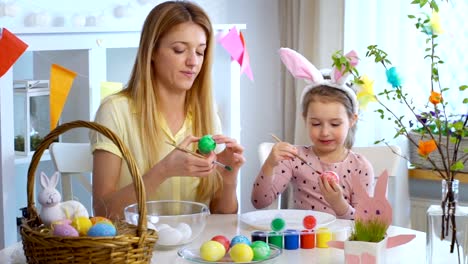 ¡Feliz-Pascua-de-resurrección!-Madre-y-su-pequeña-hija-con-divertidas-orejas-de-conejo-para-colorear-huevos-de-Pascua