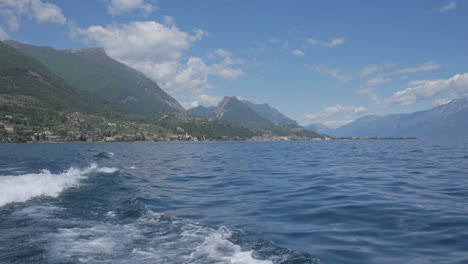 Paseo-en-bote-en-el-lago-de-Garda,-al-norte-de-Italia.-Aguas-cristalinas,-rodeado-de-montañas.