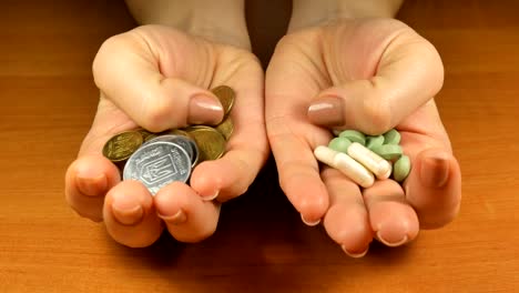 Las-mujeres-con-dinero-y-pastillas-en-las-manos-que-le-ofrece-elegir-para-la-salud