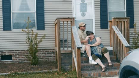 A-plus-size-couple-sitting-on-their-porch-steps-in-suburbia