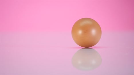 The-egg-spins-on-a-table-on-a-pink-background