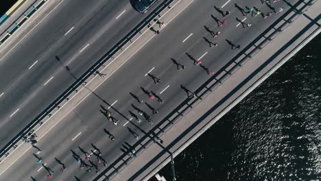 4K-Aerial-drone-fooage.-Marathon-running-on-the-bridge.-Camera-top-view