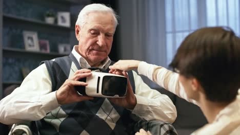 Young-Woman-Putting-VR-Goggles-on-Senior-Man