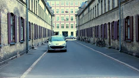 Old-streets-of-Copehagen-with-cars-and-bicycles,-ancient-architecture,-history