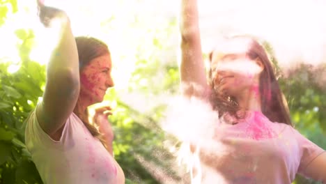 Ladies-spraying-colorful-powder-into-air-and-kissing-in-bright-cloud,-happiness