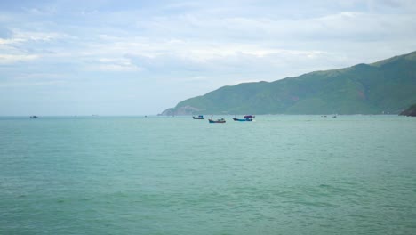 Pesca-buques-de-vela-en-el-mar-sobre-fondo-verde-de-la-montaña.-Barco-de-vela-de-océano-azul.-Hermoso-mar-turquesa-y-paisaje-de-montaña