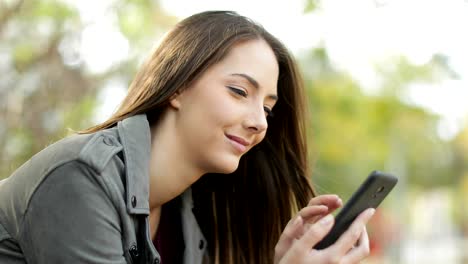 Entspannte-Frau-mit-einem-smart-Phone-in-einem-park