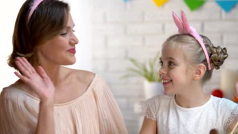 Mother-and-kid-packing-dyed-Ester-eggs-in-box,-giving-high-five-to-each-other