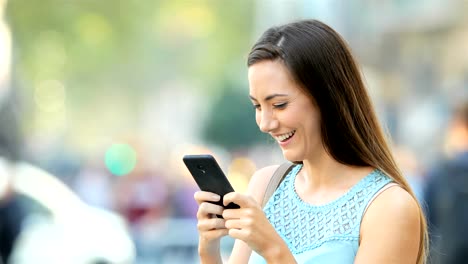 Enviar-mensajes-de-texto-feliz-señora-de-teléfono-afuera-en-la-calle