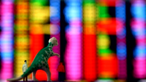 Dinosaur-and-men-doll-looking--stock-exchange-monitor