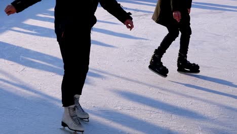 Multitud-de-personas-están-patinando-en-la-pista-de-hielo-en-el-día-soleado.-Cámara-lenta