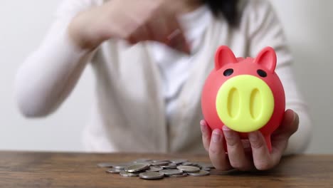 business-woman-hand-coin-and-piggy-bank